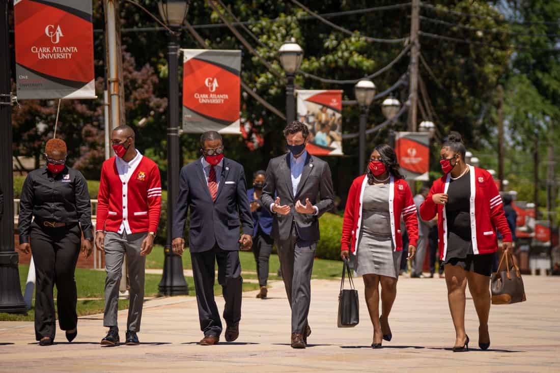 Senator Ossoff walking on campus with representatives of Clark Atlanta University.